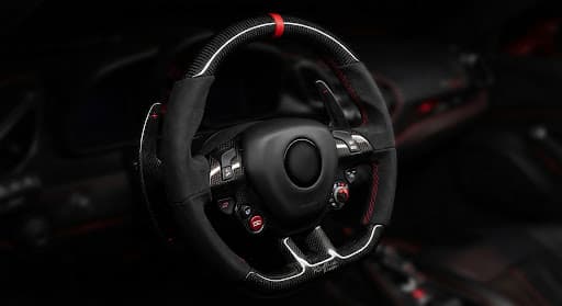 Carbon-fiber supercar steering wheel with red stitching and paddle shifters